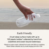 A hand holding a water bottle by the ocean showing the earth friendly value of the Beautyrest Harmony Lux Hybrid mattress  || series: Exceptional Seabrook Island || feel: firm